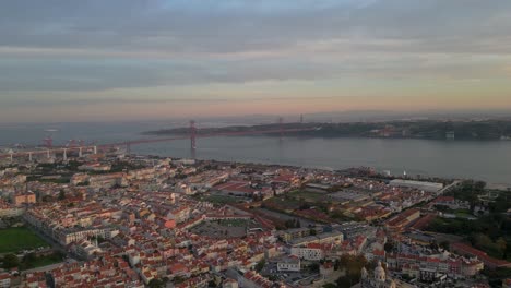 aerial view of lisbon focusing on the 25 de abril bridge just before sunset