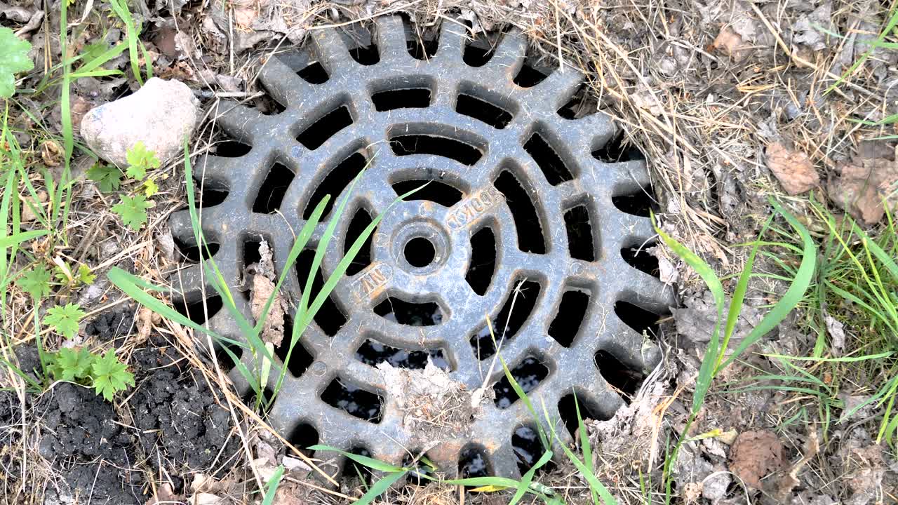 un agujero del drenaje fuera del césped