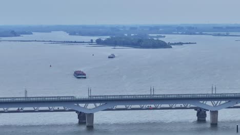 panning tiro aéreo: puentes de moerdijk con barcos de carga y cruce ferroviario