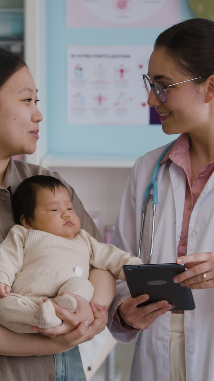 Doctor examining baby with mother present