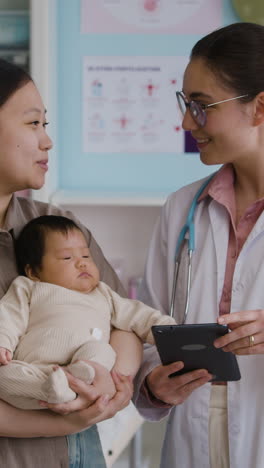 doctor examining baby with mother present