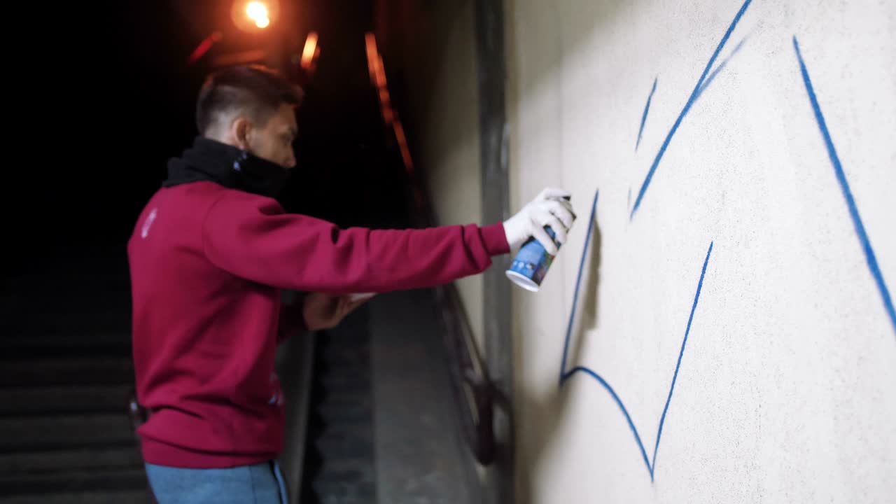 artista de graffiti pintando en la pared en el metro