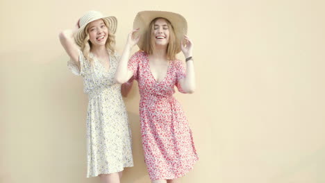 two women in floral dresses and straw hats