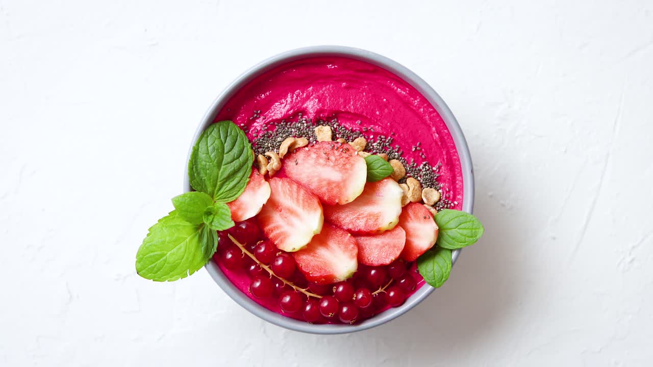 Summer berry smoothie or yogurt bowl with strawberries  red currants and chia seeds on white