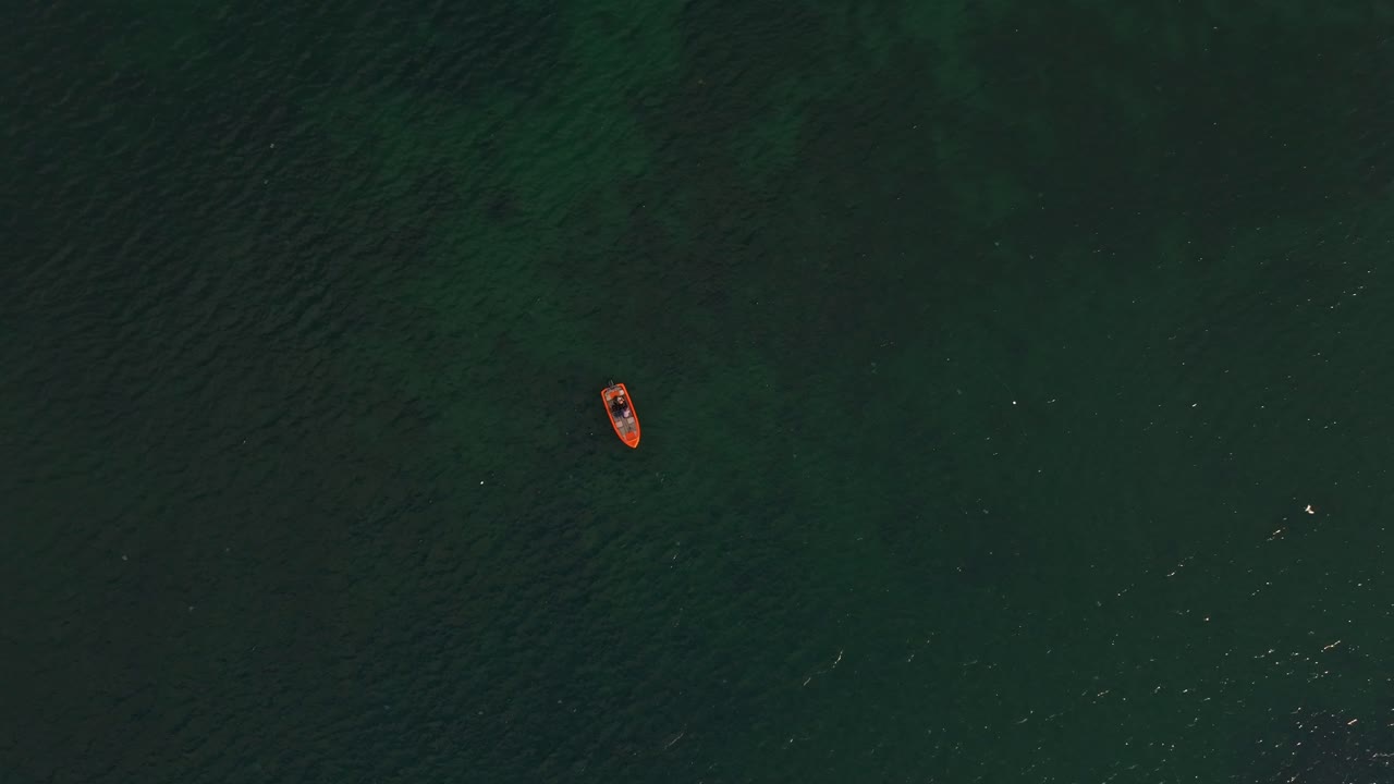 Mare tranquillo riflette il cielo dell'alba e una solitaria imbarcazione da pesca, Bulgaria