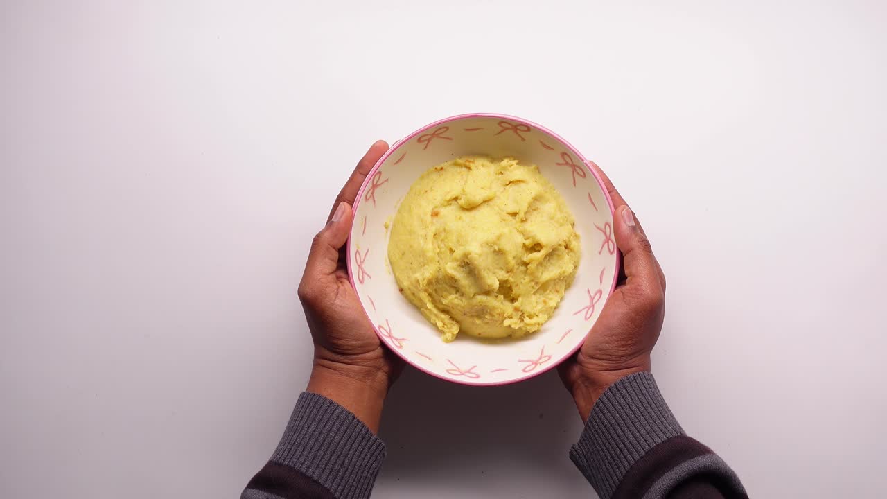 Hands Holding a Bowl of Creamy Mashed Potatoes