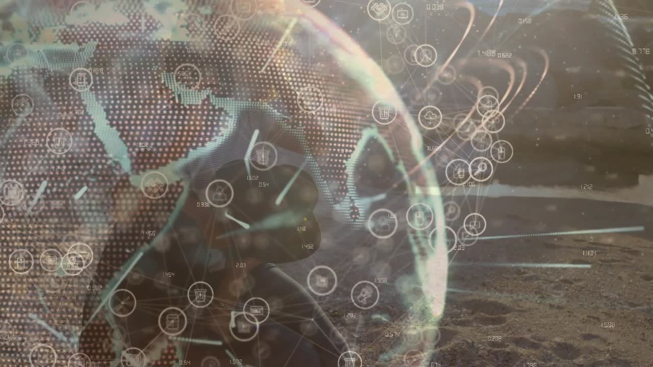 Colleghi accovacciati che attivano una demo tecnologica con globo trasparente, osservando linee di rete rotanti su una spiaggia.