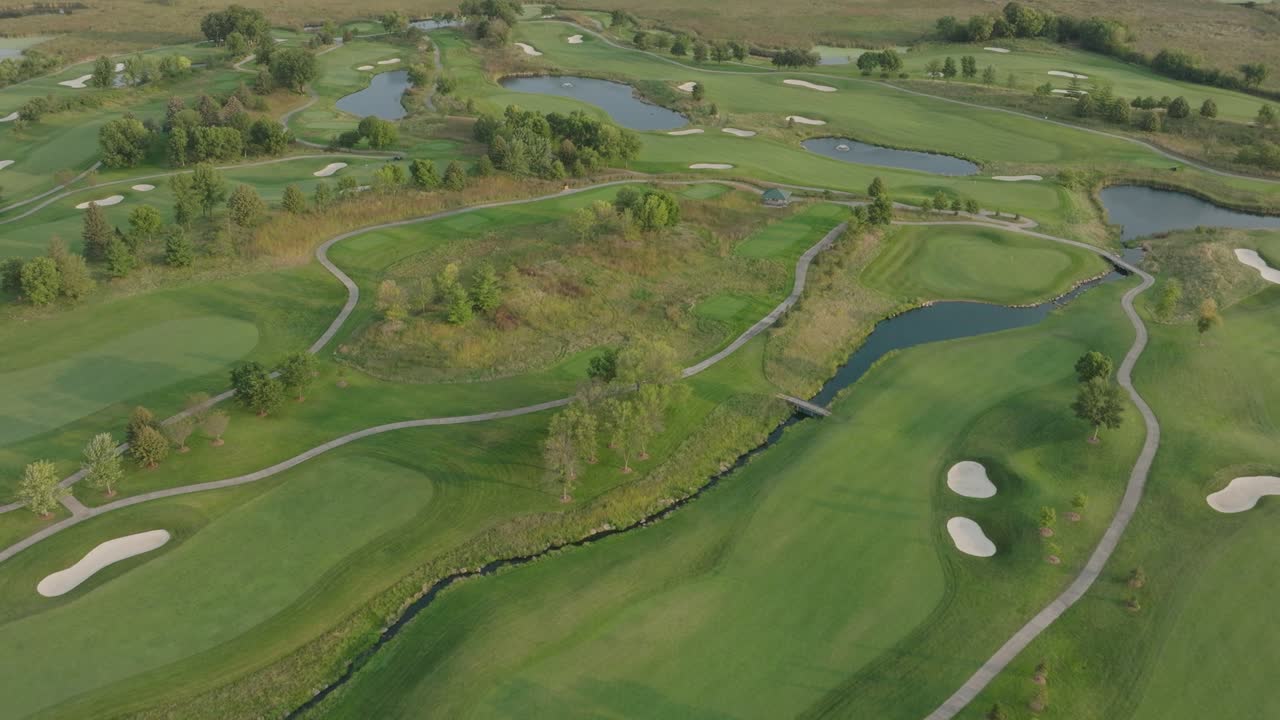 Aerial view of golf course with ponds in USA. Pullback shot.