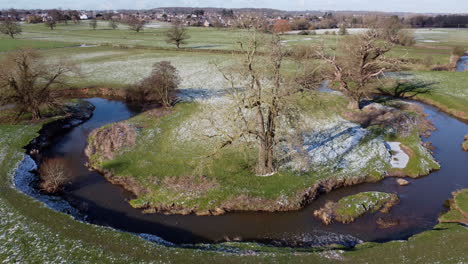 an aerial view of the twisting river arrow running through fields in warwickshire, england on a sunny frosty winter morning