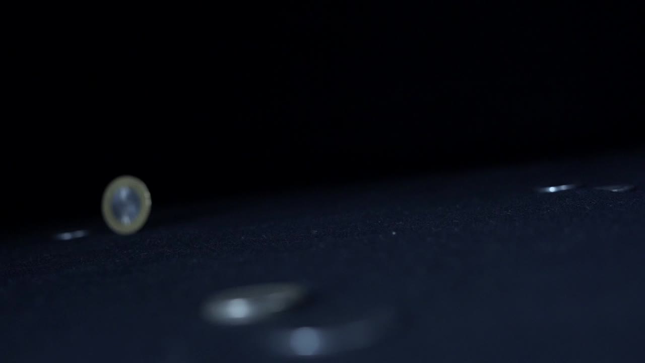 una mano está haciendo rodar la moneda india de 10 rupias de derecha a izquierda