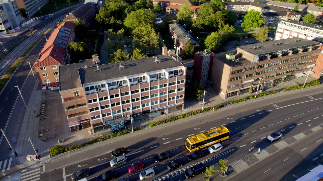 Vídeo aéreo de un moderno edificio de apartamentos y una calle concurrida en el centro de Copenhague, Dinamarca, en un día soleado