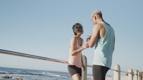 Happy-biracial-couple-drinking-juice-on-promenade,-in-slow-motion