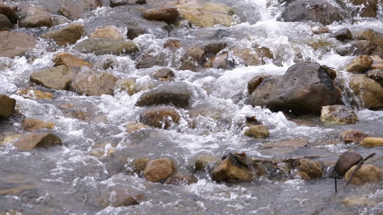 Ruscello limpido che scorre tra massi di pietra. Fiume copioso che scorre al rallentatore.