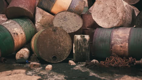 barriles oxidados esparcidos por un sitio industrial descuidado a la luz del día