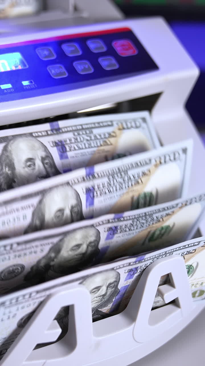 Modern electronic machine. Machine counter automatically calculates a large amount of dollar banknotes. Top view. Business accounting. Vertical video