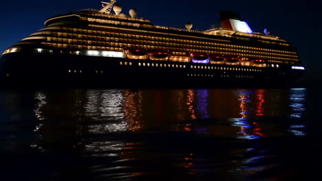 illuminated cruise ship reflecting on water at night