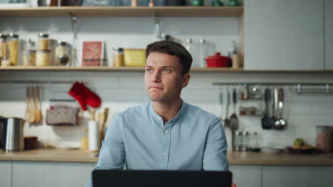 man making conference video call on laptop sitting at home kitchen close up.