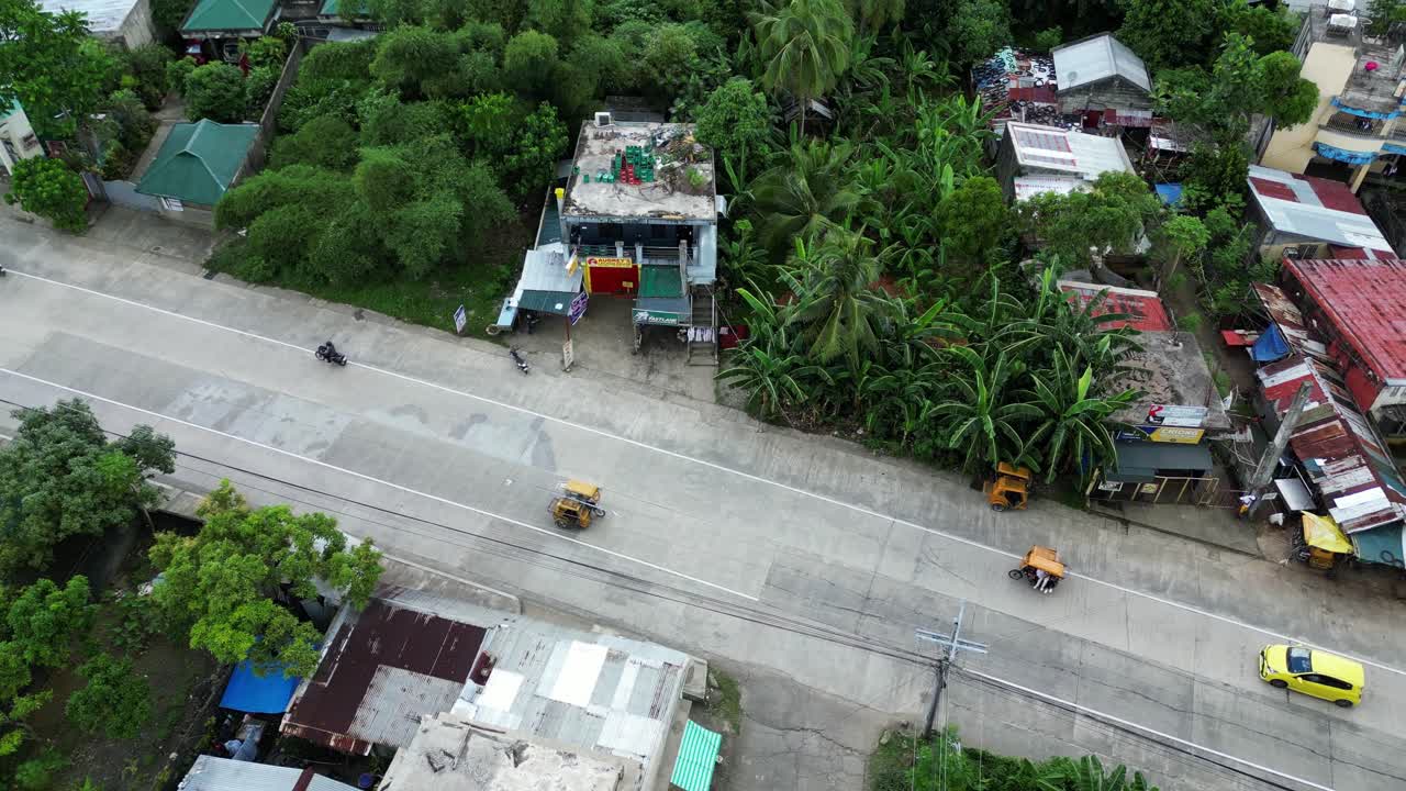 열대 아시아 마을 마을의 바쁜 거리의 공중 드론 촬영 모 ⁇ , 삼 ⁇ 자전거 및 자동차 운전