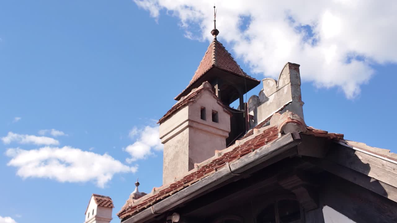 Primo piano dei tetti piastrellati del Castello di Bran con un camino ben visibile e texture architettoniche medievali