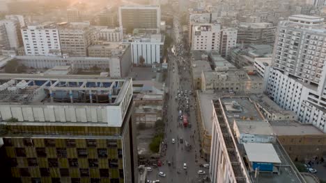 Aerial-Flying-Over-Modern-Office-Building-In-Karachi-During-Sunset-Light-With-Birds-Flying-Around