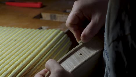 macro close up of artisan luthier maker work on new classic handmade raw violin smooth edge in waist and purfling rasp in workbench of workshop in cremona italy 4k video