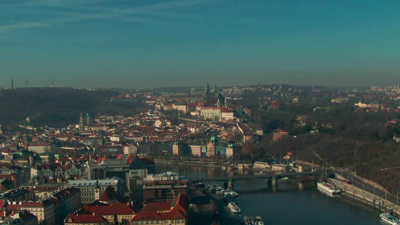 volo del drone sul fiume vlatava di praga che mostra il sole invernale degli edifici e del parco del castello dei ponti