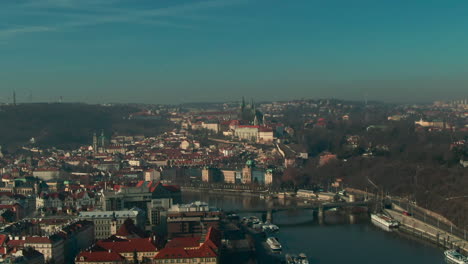 drone flight over prague vlatava river showing bridges castle park and buildings winter sunshine