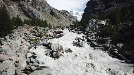 torrente fangoso en un valle de los alpes suizos junto a las cumbres de las montañas rocosas, el glaciar se derrite debido al calentamiento global