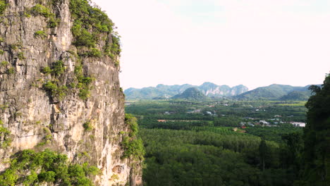 flying towards rock limestone mountains revealing coastline view near andaman sea in krabi province, ao nang, thailand