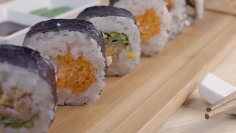 Slider-Dolly-Tiro-De-Sushi-En-Un-Plato-De-Sering-De-Madera-Con-Palillos