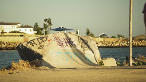 Person-fails-to-make-jump-with-skateboard-on-concrete-ramp-in-Los-Angeles-coastline