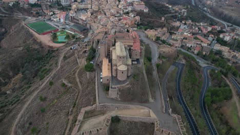 Burg-Von-Cardona-Und-Die-Umliegende-Stadt-In-Der-Abenddämmerung,-Luftaufnahme