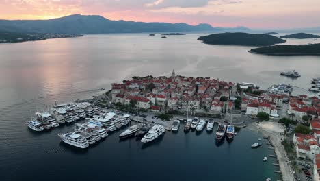 aerial drone video panning to the right around the old walled town of korcula in the croatian islands at sunrise