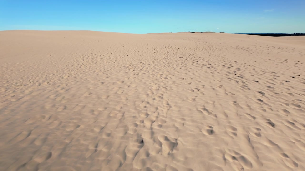 Ampia veduta di una duna di sabbia desertica di Rabjerg Mile, con sabbia ondulata e cielo azzurro limpido, che mostra un paesaggio naturale vuoto con spazio per il testo.