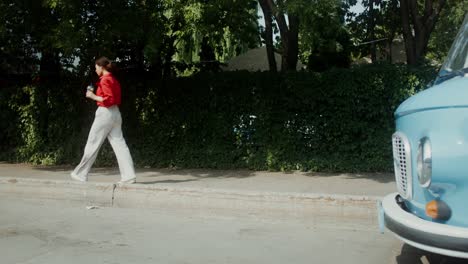 woman walking on city street near vintage van