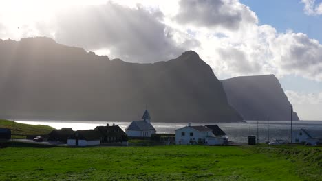 sunrays through clouds over faroese landscape in vidareidi, faroe islands