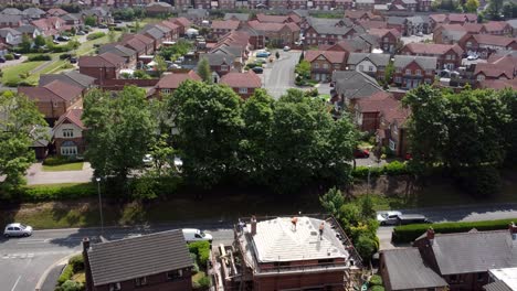 Modern-red-brick-housing-development-aerial-view-tilt-down-to-builders-working-on-new-home-rooftop