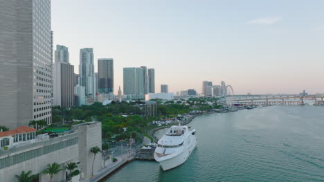 Tire-Hacia-Atrás-Del-Tiro-Del-Amarre-Del-Barco-En-El-Banco-De-La-Ciudad.-Reveladora-Vista-Panorámica-Del-Distrito-Urbano-Moderno-Y-El-Puente-Sobre-La-Bahía-Del-Mar.-Miami,-Estados-Unidos