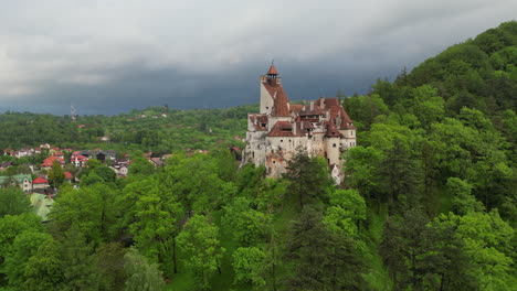 majestic bran castle, also known as dracula's castle, stands on a hilltop surrounded by lush green forest in transylvania, romania