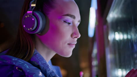 Woman-looking-snacks-vending-machine-late-evening-close-up.-Girl-in-headphones.