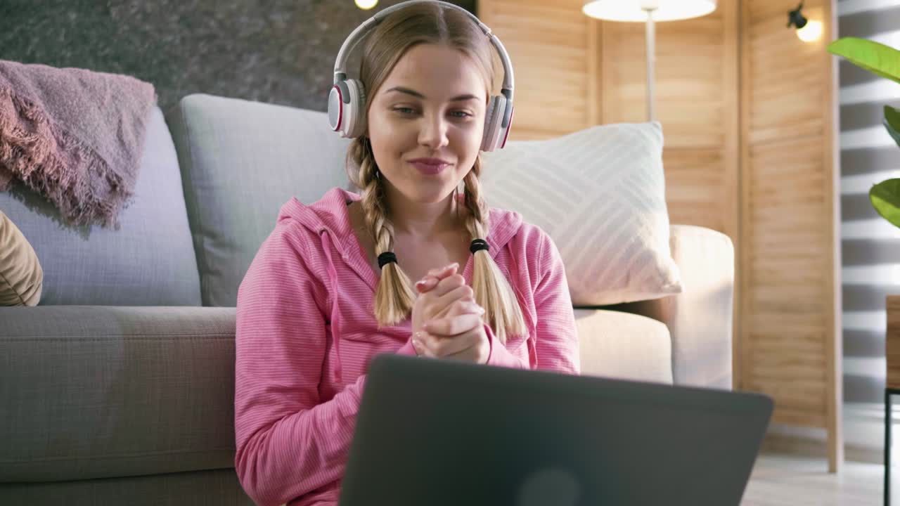 Teenager girl talking with laptop on a video call at home
