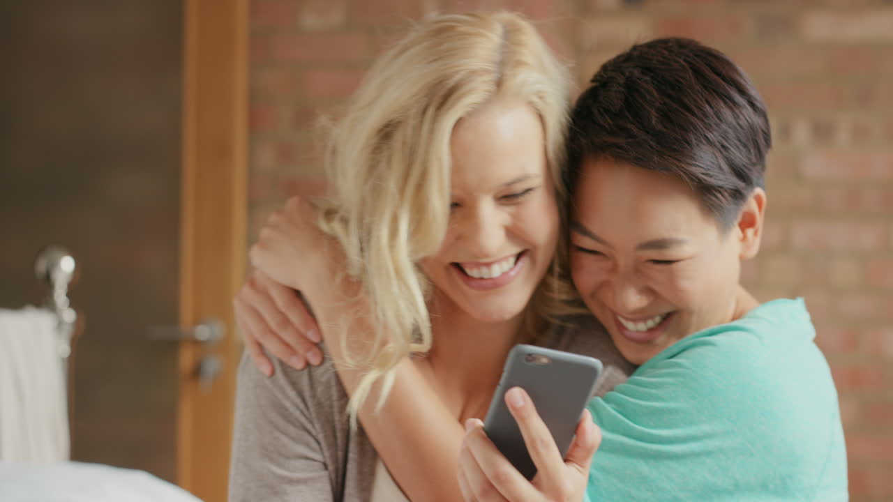 집 에서 친구 들 이 스마트 폰 을 이용 하여 웃고 즐기고 있다