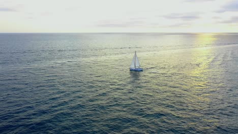 Drohnenblick-Auf-Ein-Segelboot-Bei-Sonnenuntergang-Im-Pazifischen-Ozean