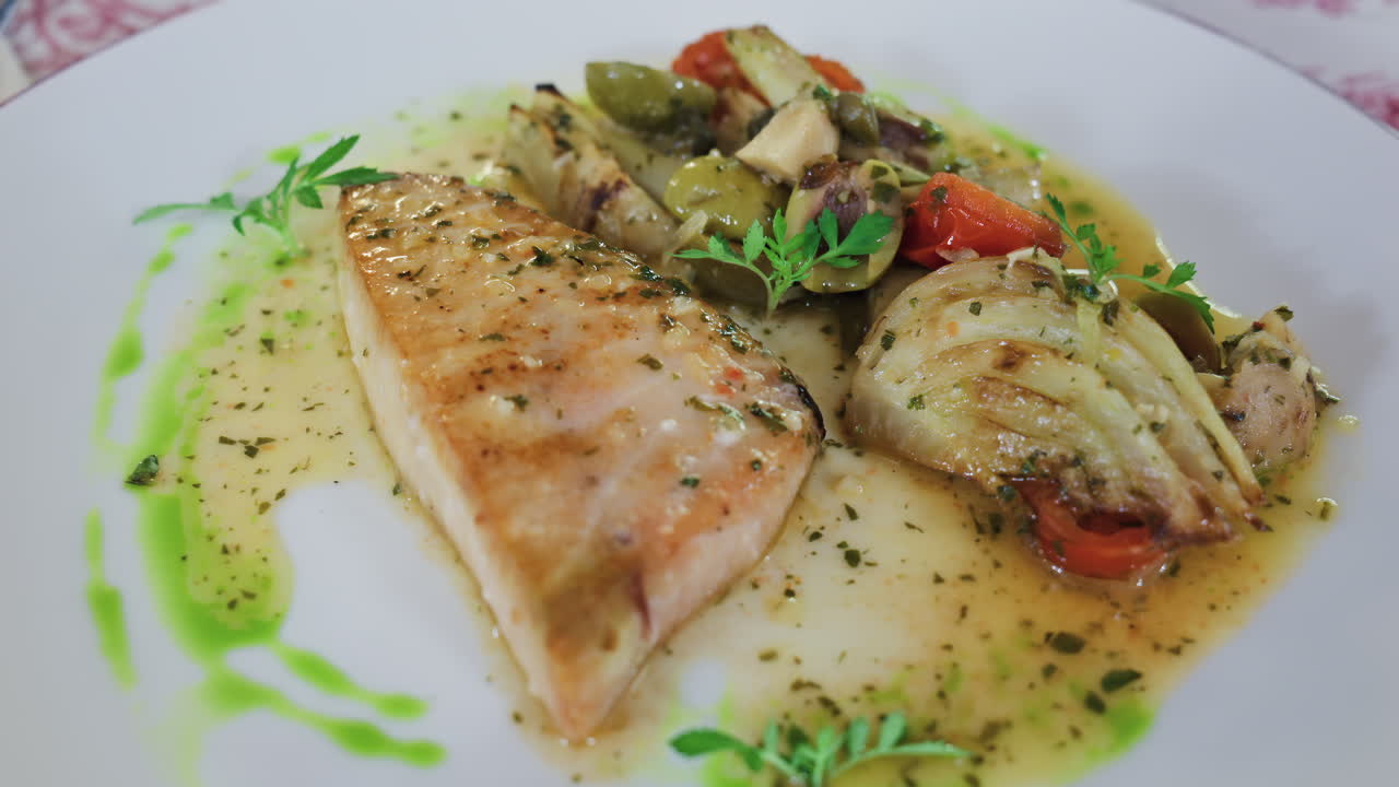 Close up of grilled salmon with vegetables on a white plate at a restaurant