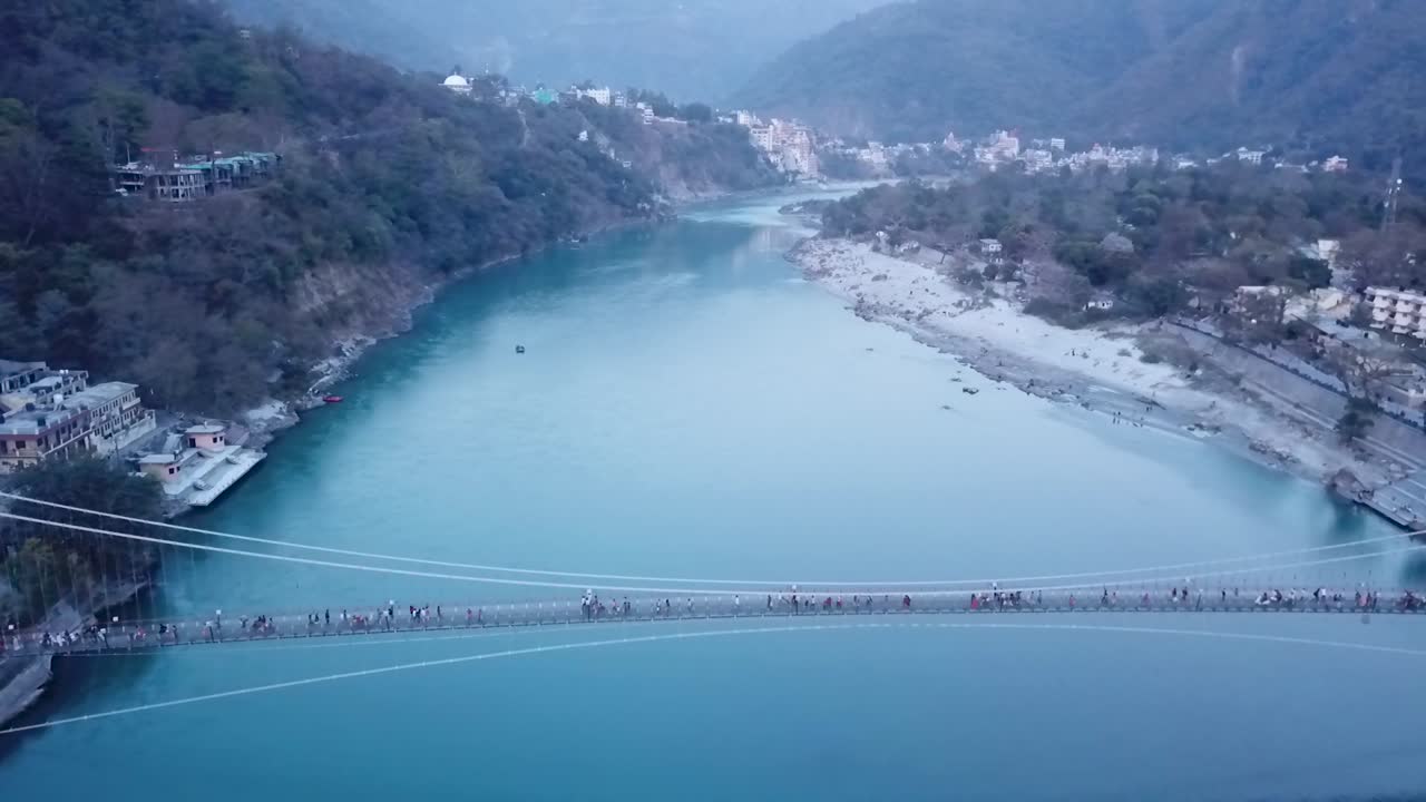 Pedestrians Crossing Ganges River Through Ram Jhula In Rishikesh, India - aerial drone
