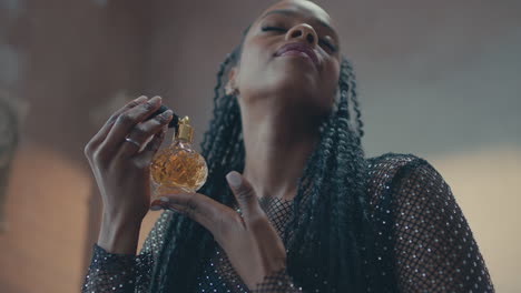 Low-angle-view-of-a-girl-using-vintage-perfume-on-her