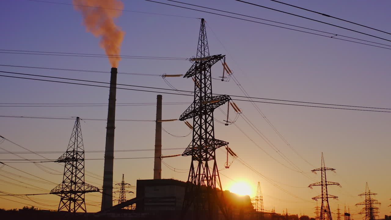 Electricity pylons and lines at dusk. Silhouette of high voltage tower and wires
