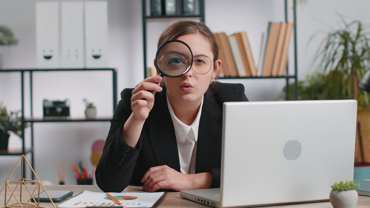 Business woman holding magnifying glass near face looking with big zoomed eye searching analysing
