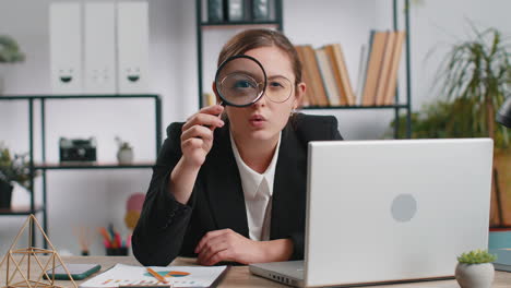 business woman holding magnifying glass near face looking with big zoomed eye searching analysing