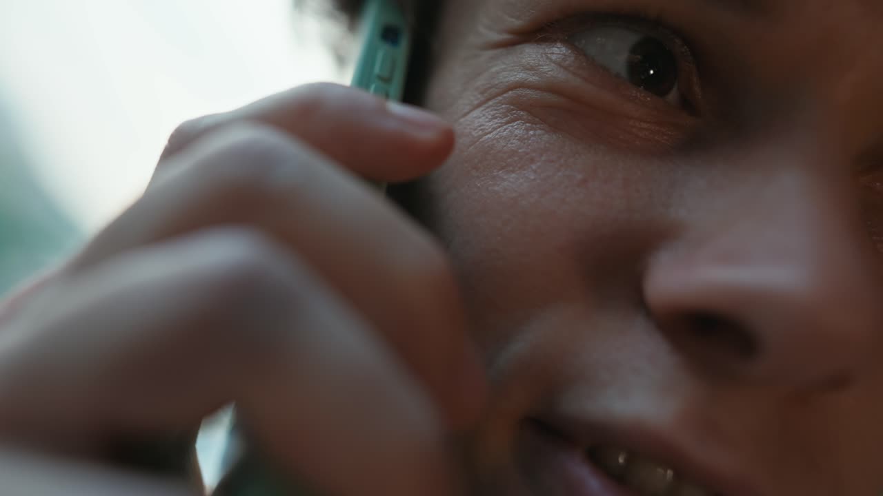 Close up a guy with curly hair takes out a green smartphone from his pants pocket and begins business communication in the office